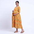 Yellow printed maternity wear with empire waist and three quarter sleeves front view 