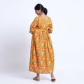 Yellow printed maternity wear with empire waist and three quarter sleeves front view 