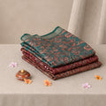 Tussar saree with multicolor artistic print, green woven border, neatly folded stack front view
