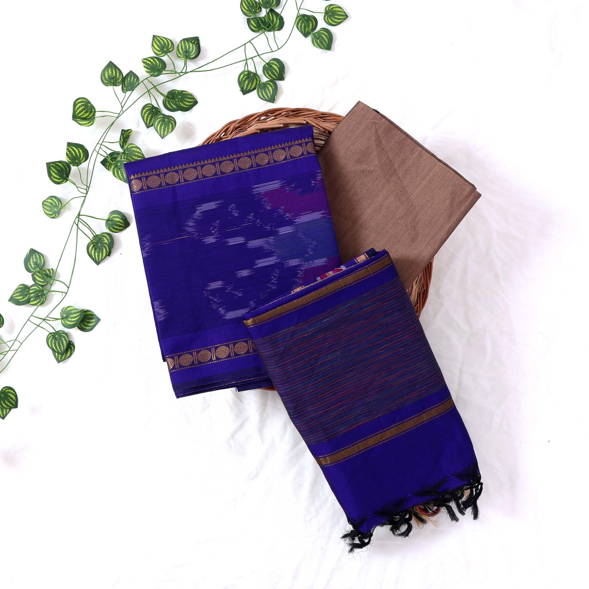 Top View Of Royal Blue And Brown Salwar Suit Material With Striped Dupatta, Ikkat Woven Border, Tassel Details & Fabric Piece