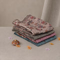 Tussar saree with multicolor artistic print, green woven border, neatly folded stack front view