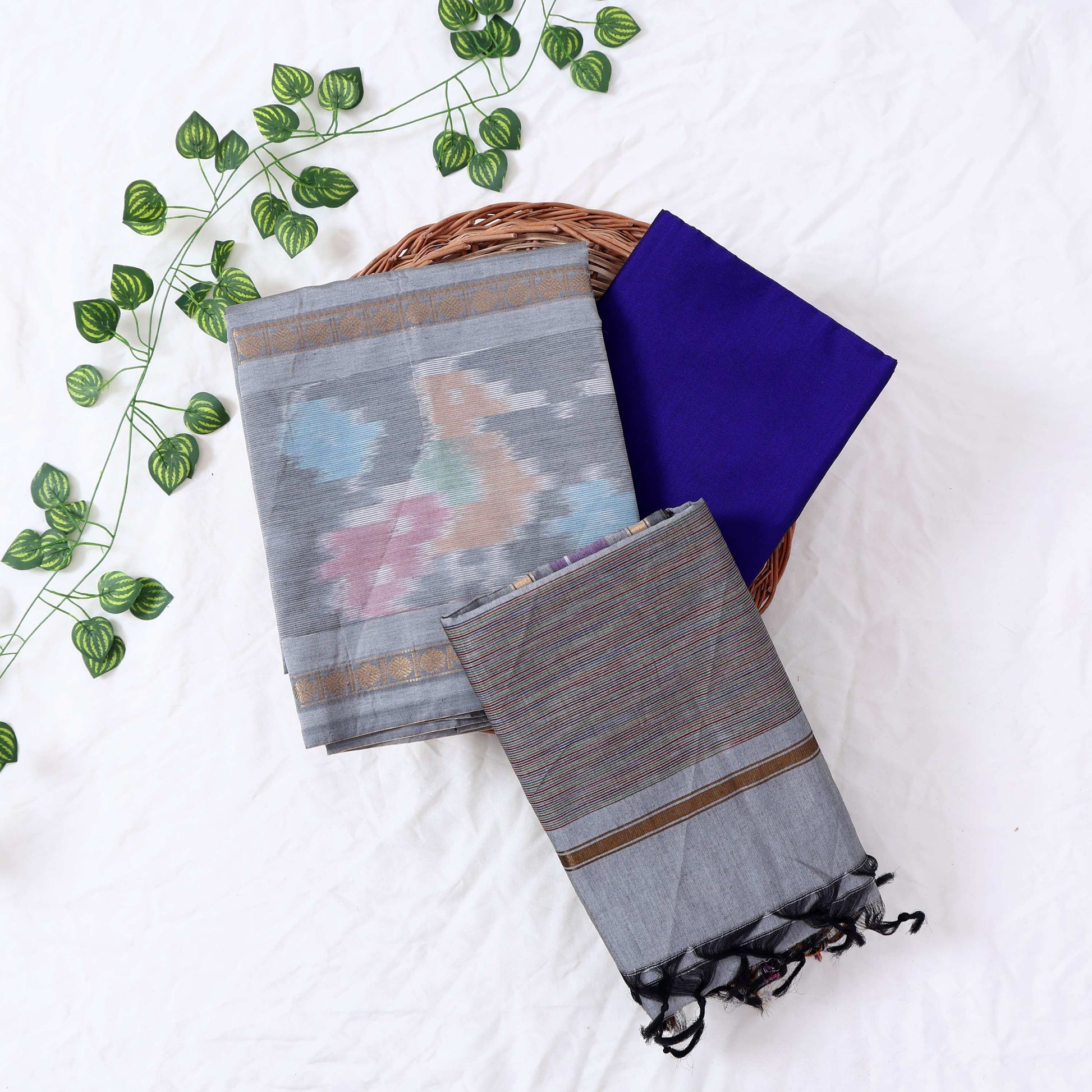 Top View Of Grey And Blue Salwar Suit Material With Striped Dupatta, Ikkat Woven Border, Tassel Details & Fabric Piece