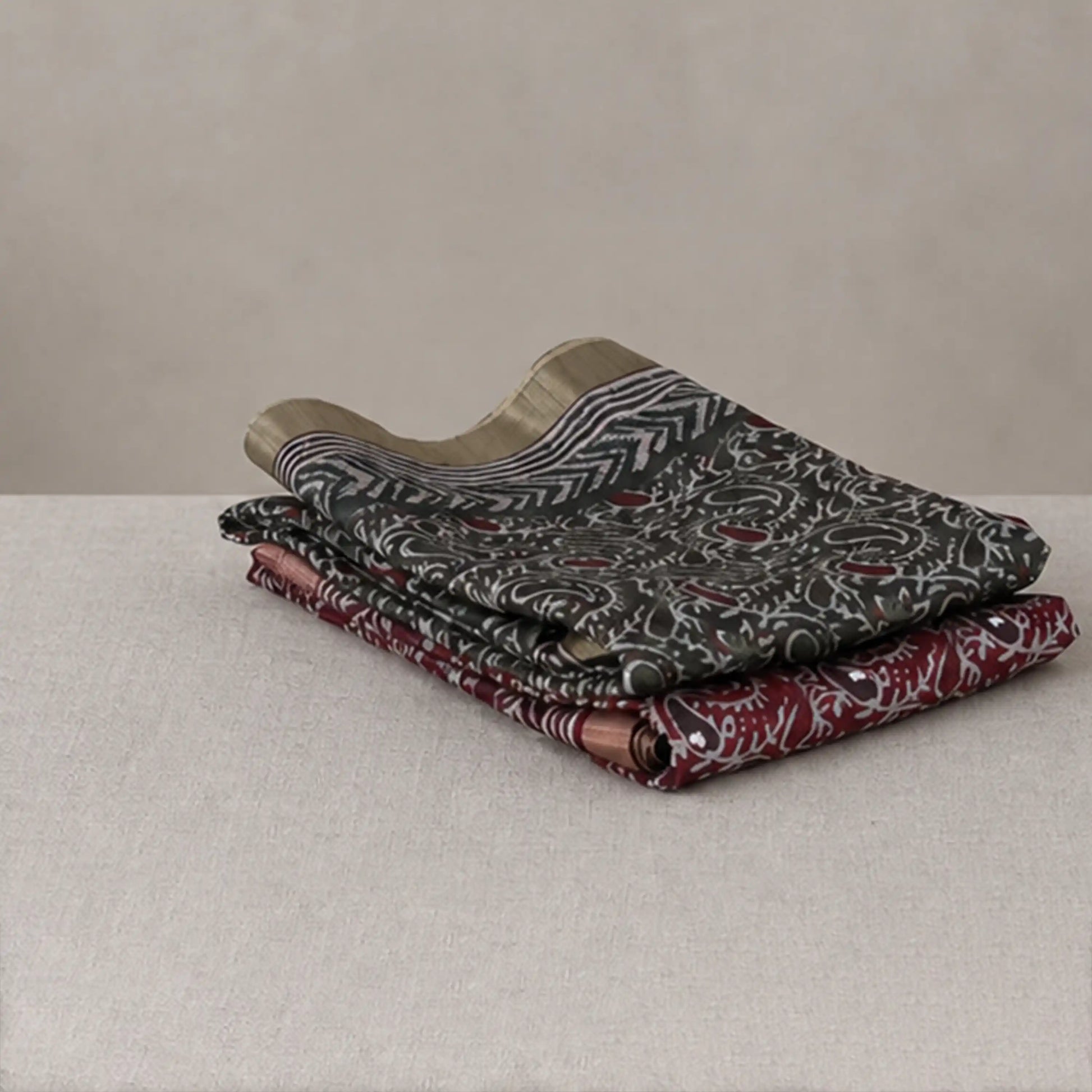 Tussar saree with multicolor artistic print, green woven border, neatly folded stack front view