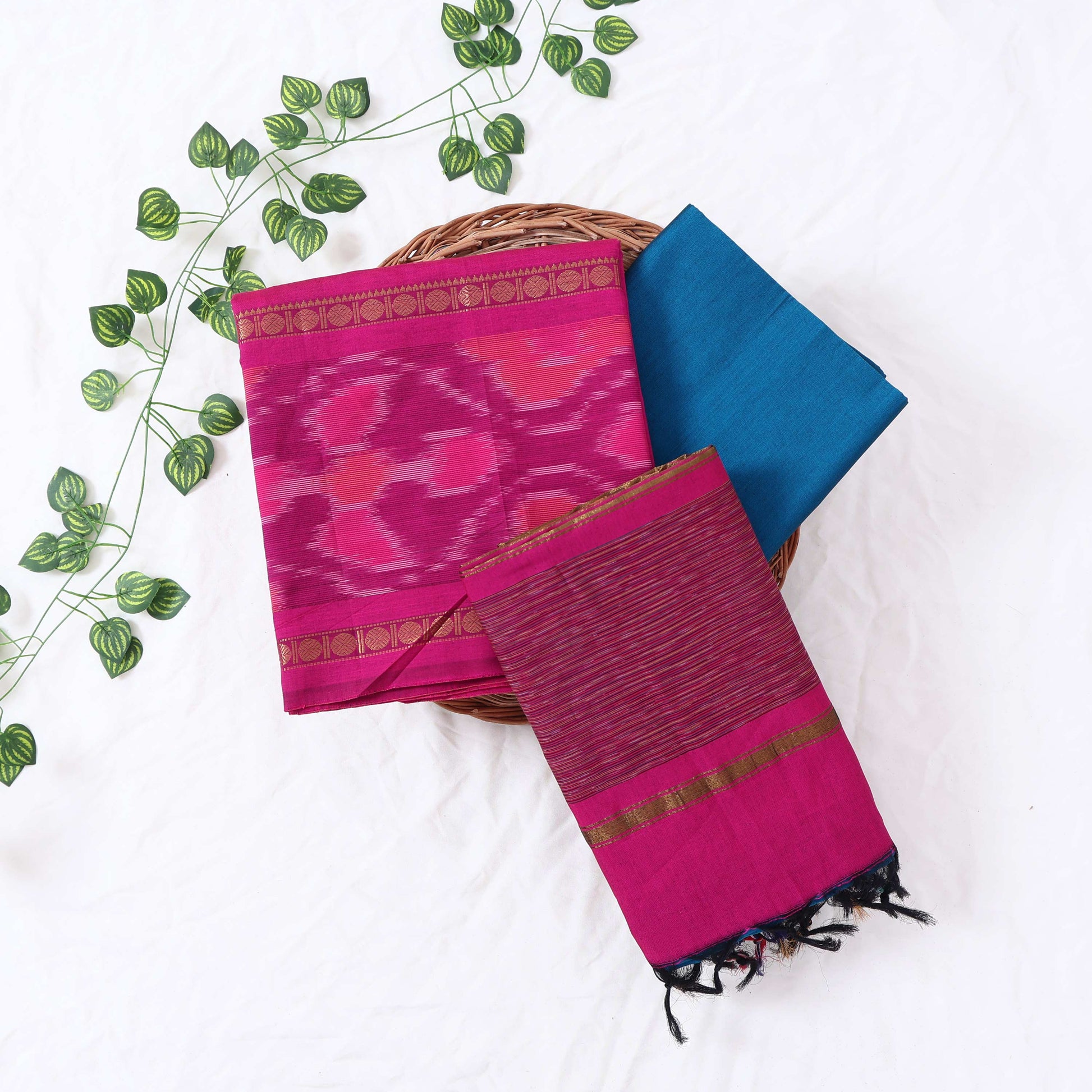 Top View Of Pink And Blue Salwar Suit Material With Striped Dupatta, Ikkat Woven Border, Tassel Details & Fabric Piece