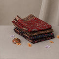 Tussar saree with multicolor artistic print, green woven border, neatly folded stack front view
