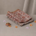 Tussar saree with multicolor artistic print, green woven border, neatly folded stack front view