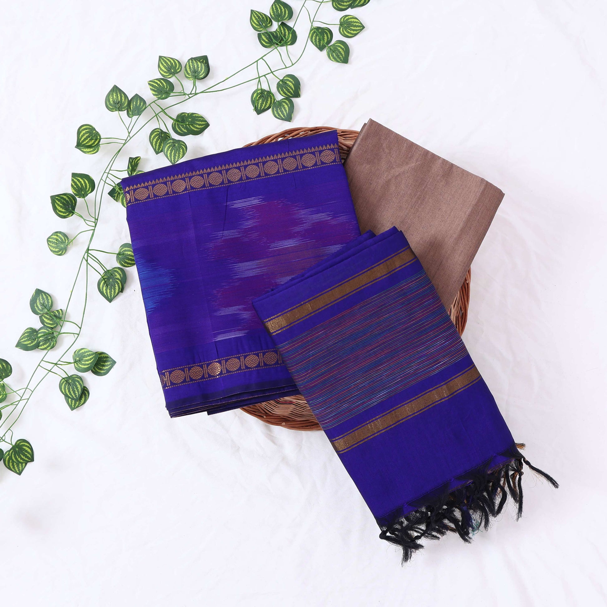 Top View Of Dark Blue And Brown Salwar Suit Material With Striped Dupatta, Ikkat Woven Border, Tassel Details & Fabric Piece