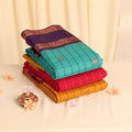 Elampillai silk cotton saree collection with checked patterns and zari borders in assorted colors folded stack close up view