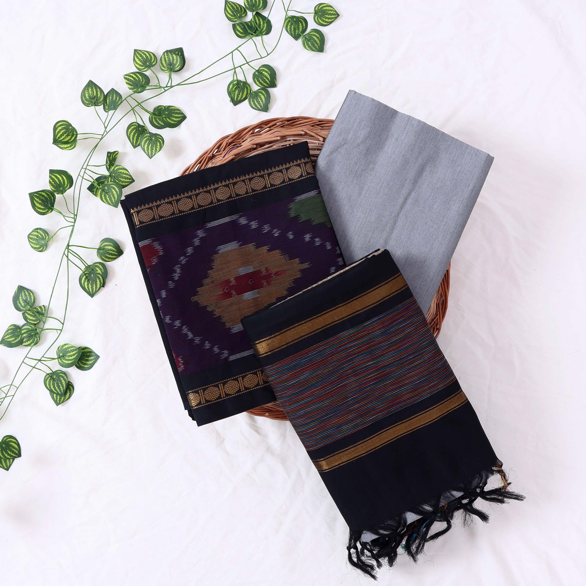 Top View Of Black And Grey Salwar Suit Material With Striped Dupatta, Ikkat Woven Border, Tassel Details & Fabric Piece