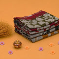 Stack of Semi Chanderi sarees with floral patterns and woven peacock zari borders side angle view.