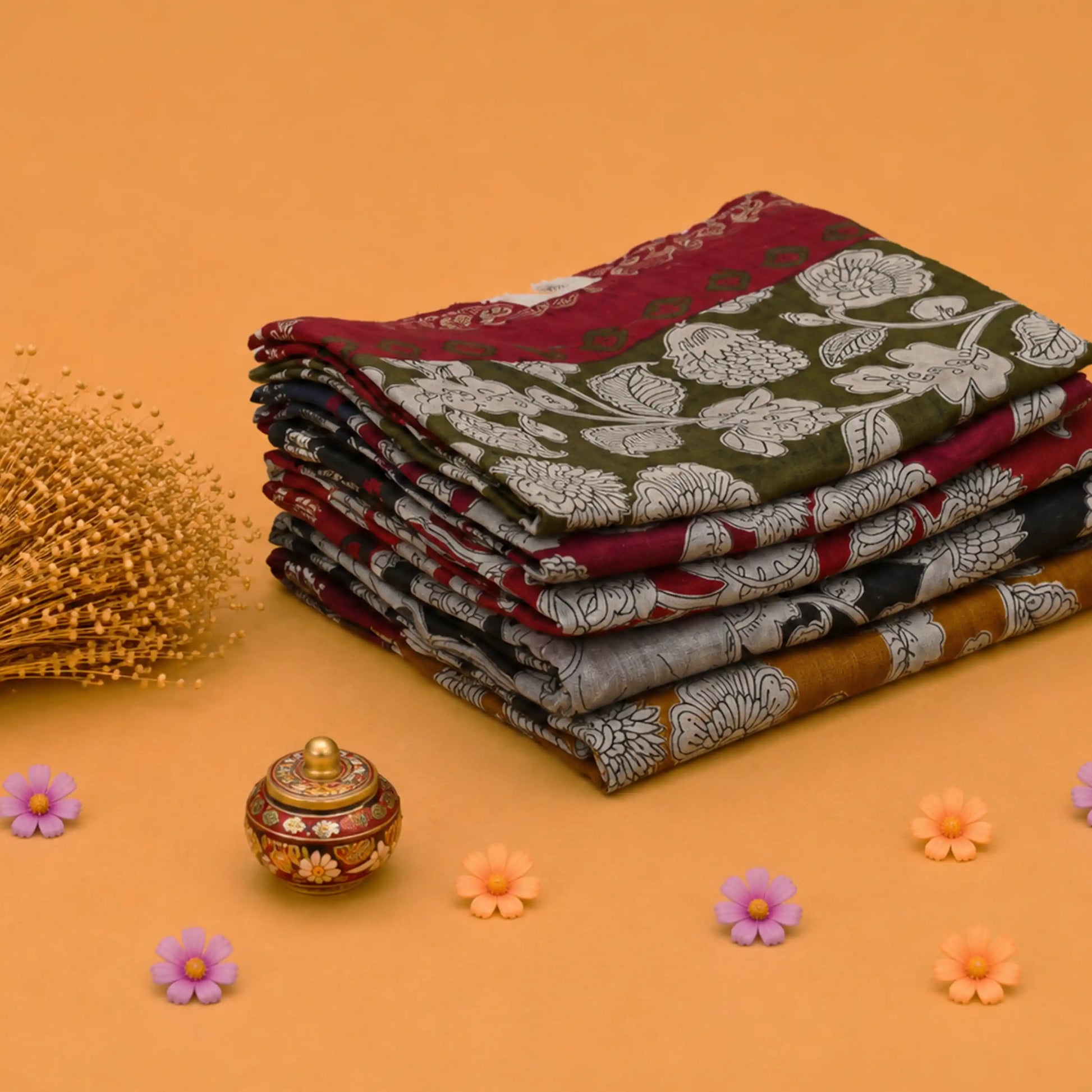 Stack of Semi Chanderi sarees with floral patterns and woven peacock zari borders side angle view.