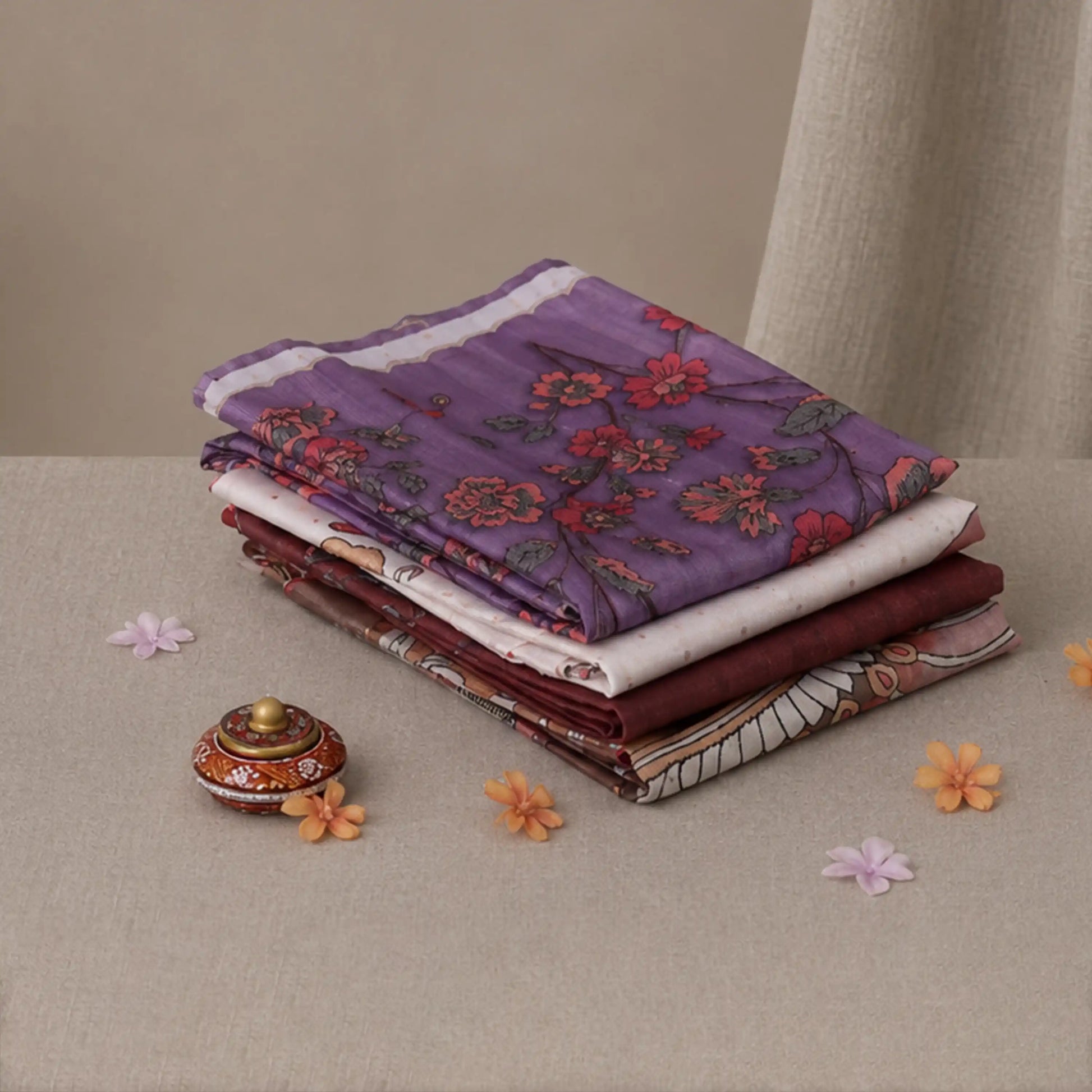 Tussar saree with multicolor artistic print, green woven border, neatly folded stack front view