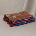 Tussar saree with multicolor artistic print, green woven border, neatly folded stack front view