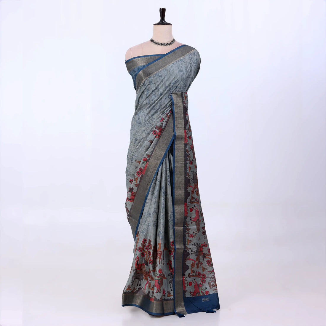 A grey and blue saree with red floral patterns and a metallic gold border.