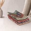 Tussar saree with multicolor artistic print, green woven border, neatly folded stack front view