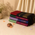 Folded checked kalyani cotton sarees in assorted colors with zari woven borders, stacked display