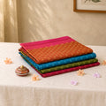 Voile cotton sarees with woven butta motifs in assorted colors neatly folded stack display top front view
