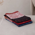 Tussar saree with multicolor artistic print, green woven border, neatly folded stack front view