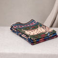 Tussar saree with multicolor artistic print, green woven border, neatly folded stack front view