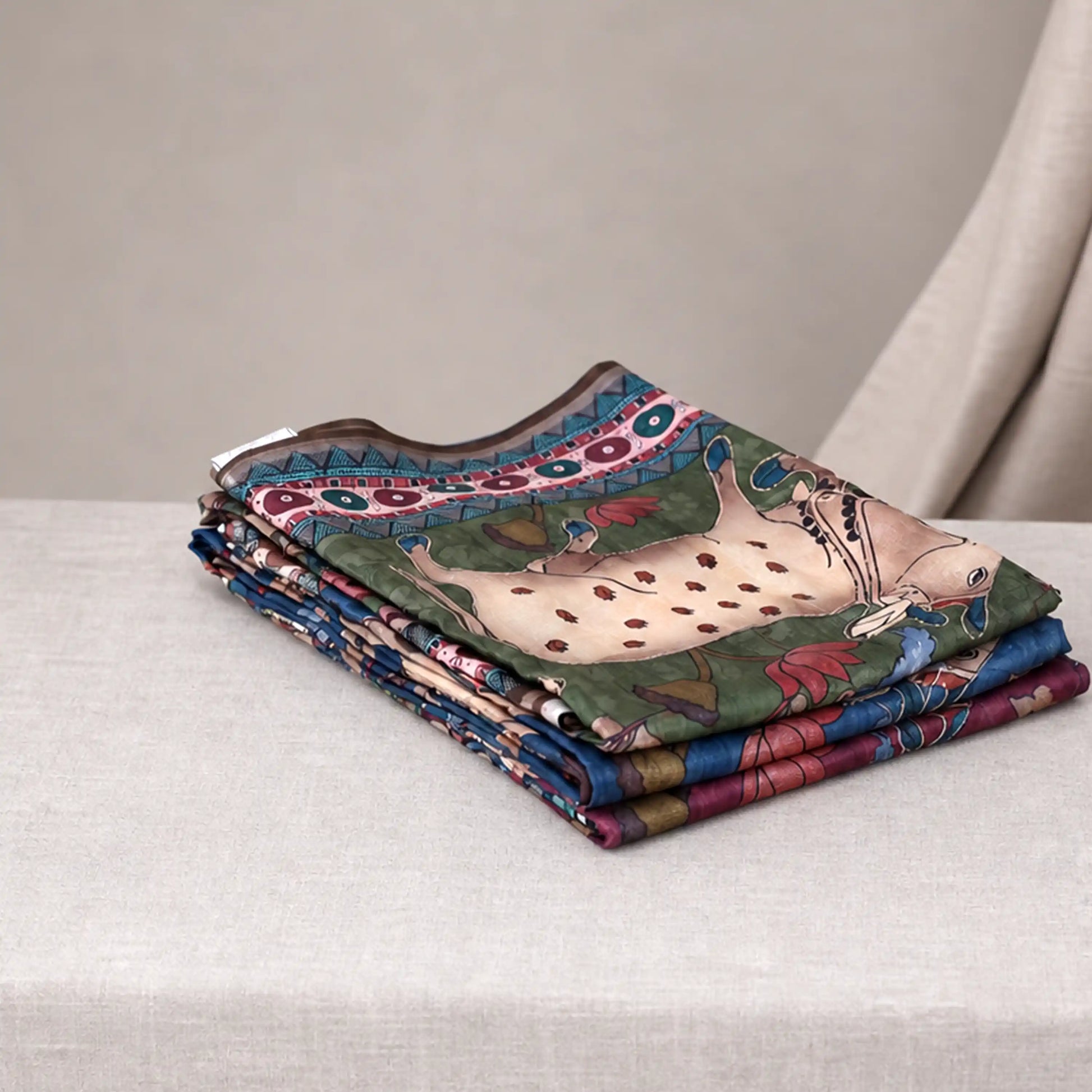 Tussar saree with multicolor artistic print, green woven border, neatly folded stack front view
