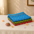 Voile cotton saree collection stack with blue floral print saree on top, folded display view
