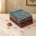 Art silk saree collection with vibrant paisley prints in multicolor shades folded stack view showcasing assorted designs
