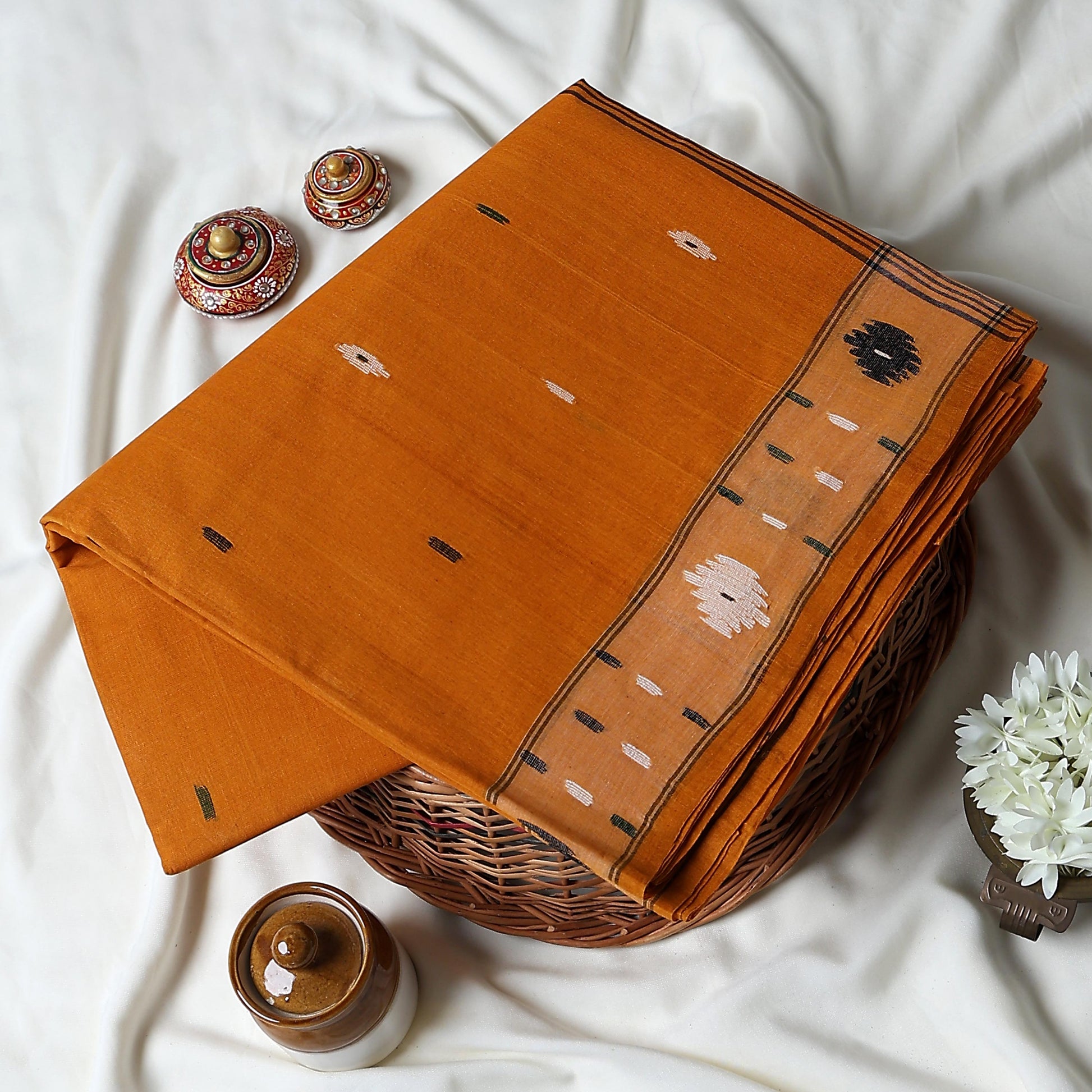 Bengal Cotton Saree With Woven Buti Motifs And Contrast Border In Orange Folded Display  - Close Up View