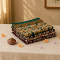Voile cotton saree with floral block print and teal border multicolor folded stack front close up view on table