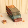 Assorted Elampillai silk cotton sarees with floral zari buttas, striped body and contrast zari border stacked folded view