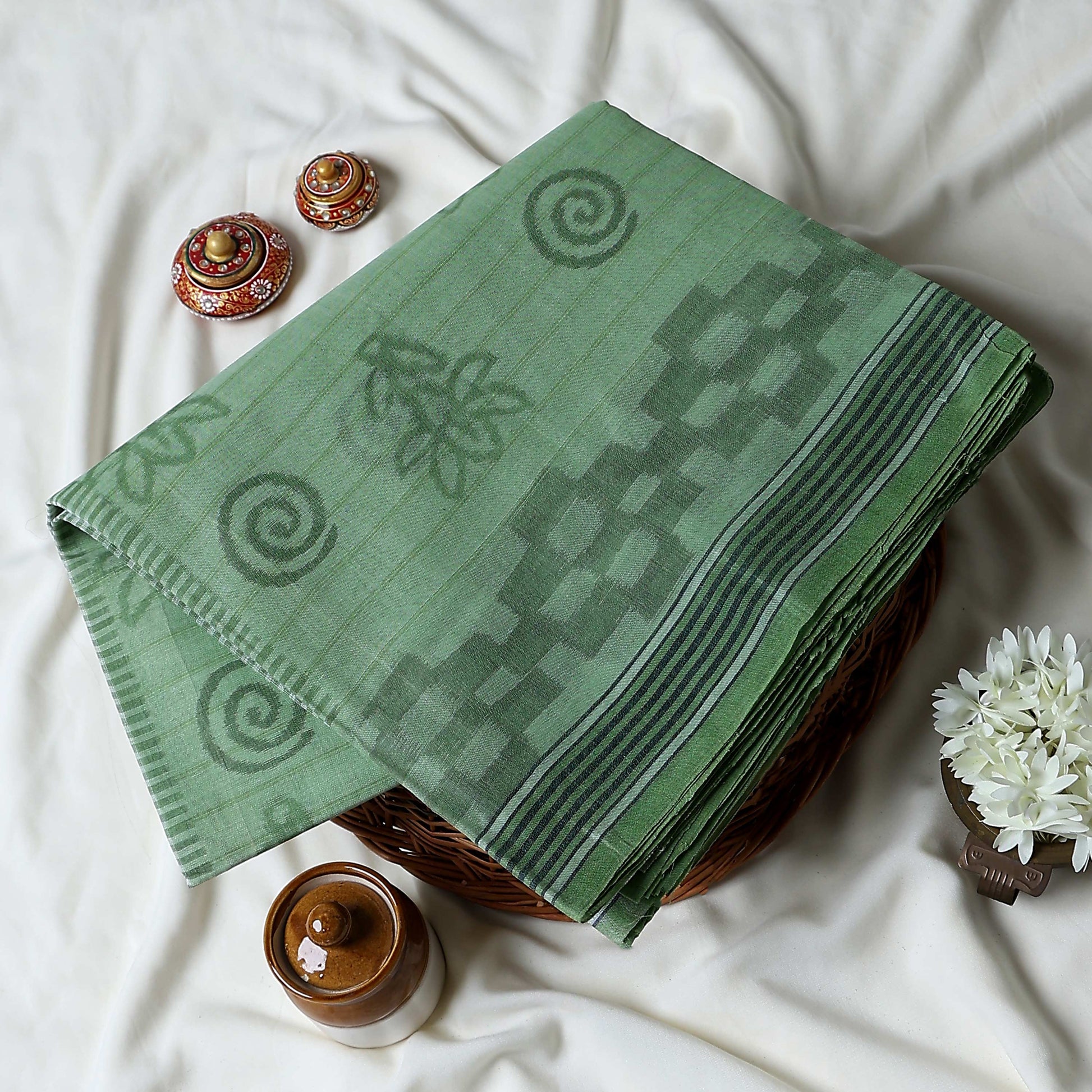 Bengal Cotton Saree With Self-Woven Floral And Spiral Motifs In Green Folded Display With Striped Border Close Up View