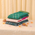 Sungudi cotton saree with checked pattern and Bandhani motifs in teal, pink and white folded stack close-up view