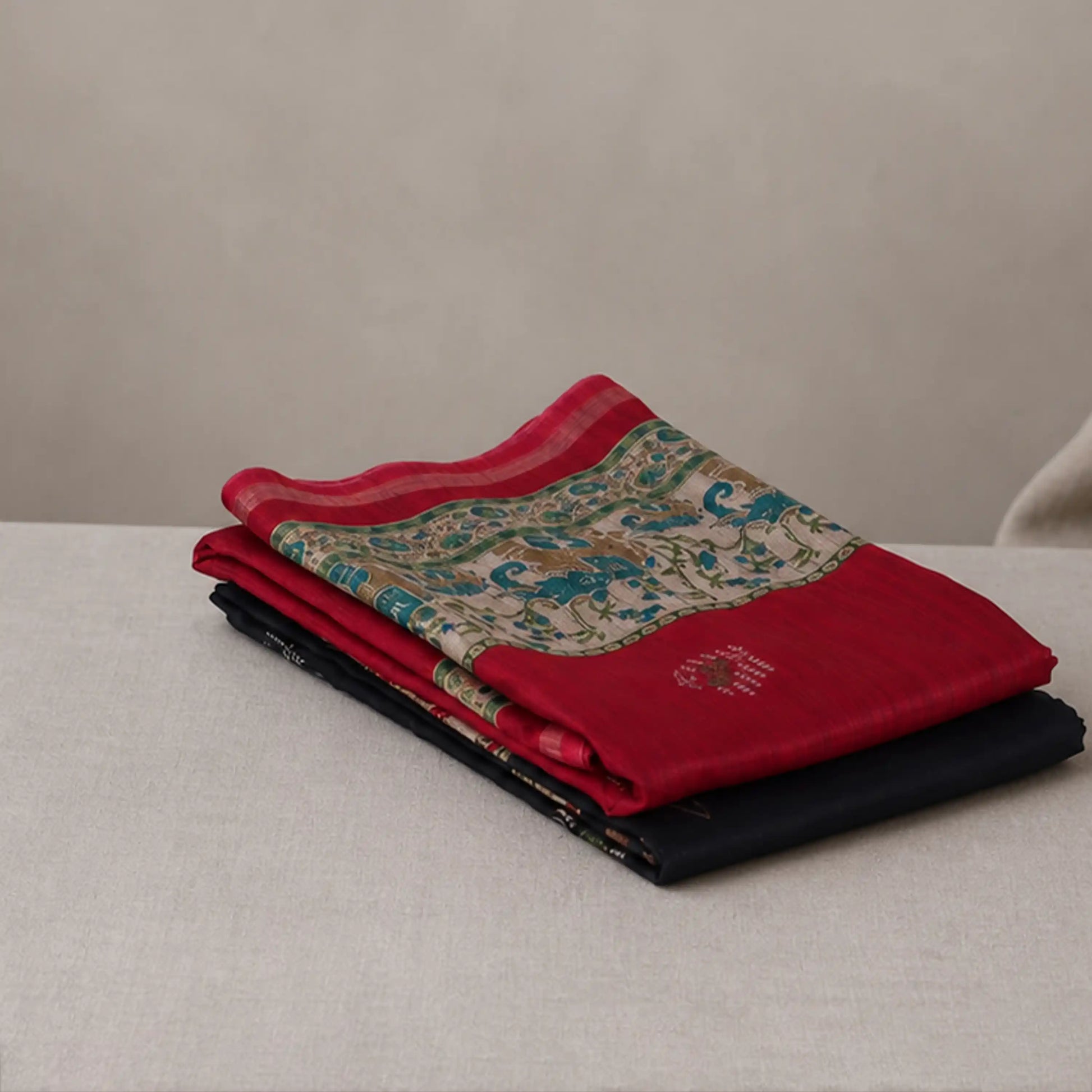 Tussar saree with multicolor artistic print, green woven border, neatly folded stack front view