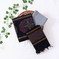 Top View Of Black And Grey Salwar Suit Material With Striped Dupatta Ikkat Woven Borders,Tassel Details And Matching Fabric Piece