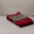 Tussar saree with multicolor artistic print, green woven border, neatly folded stack front view