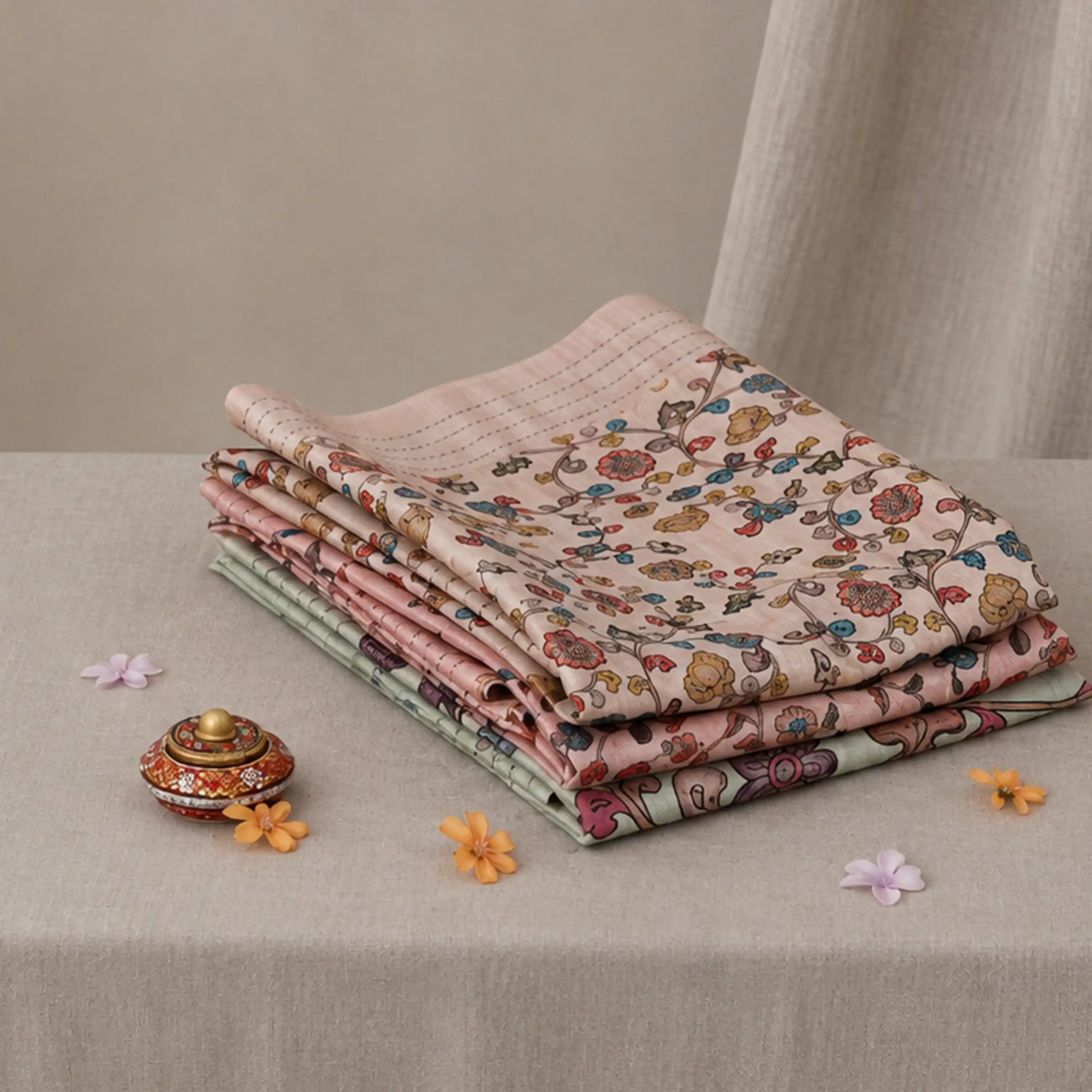 Tussar saree with multicolor artistic print, green woven border, neatly folded stack front view