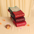 Elampillai silk cotton saree with silver zari border in pink,red and purple folded stack display front view.