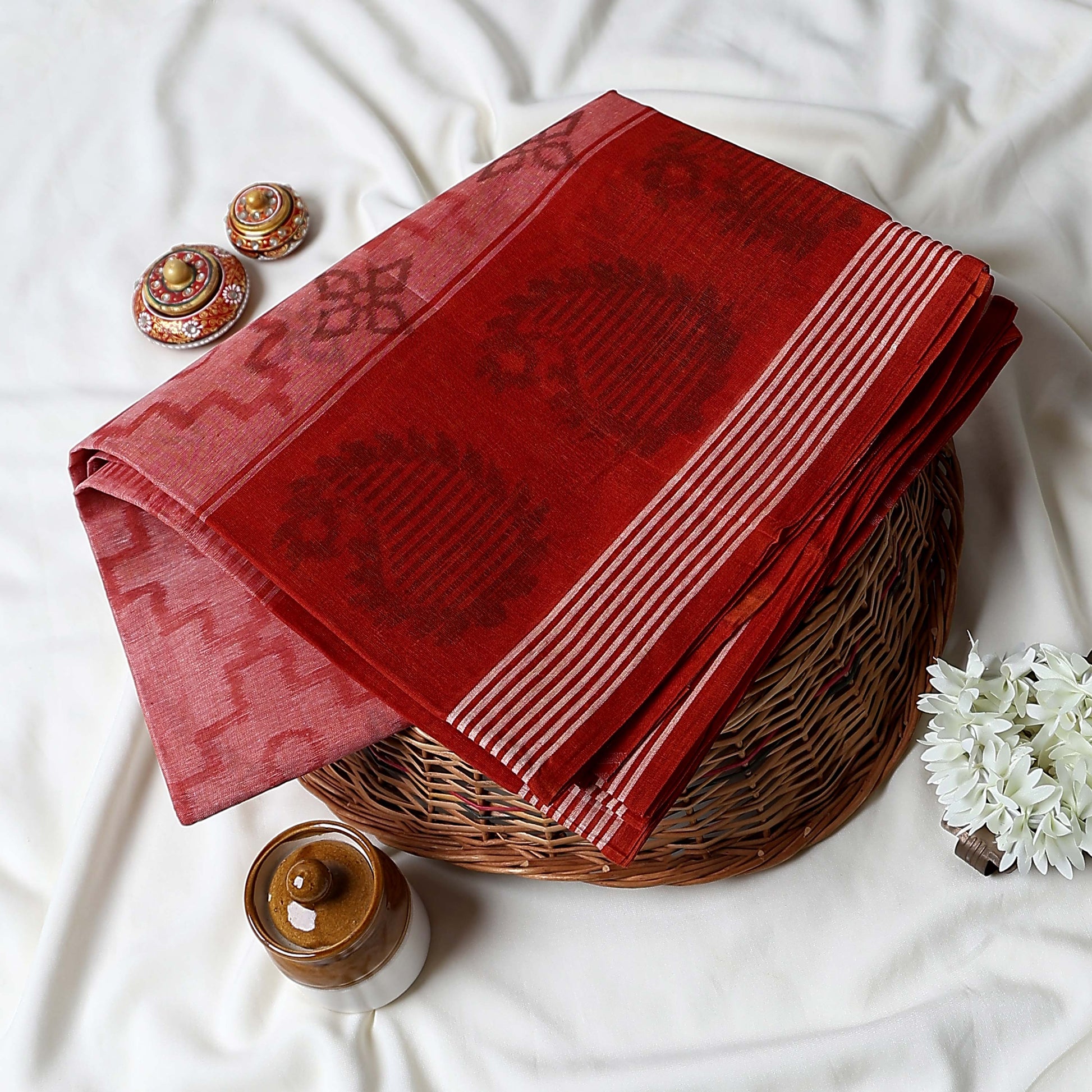 Red Bengal Cotton Saree Featuring Floral Butta Motifs And Striped Border Folded Product Close Up View