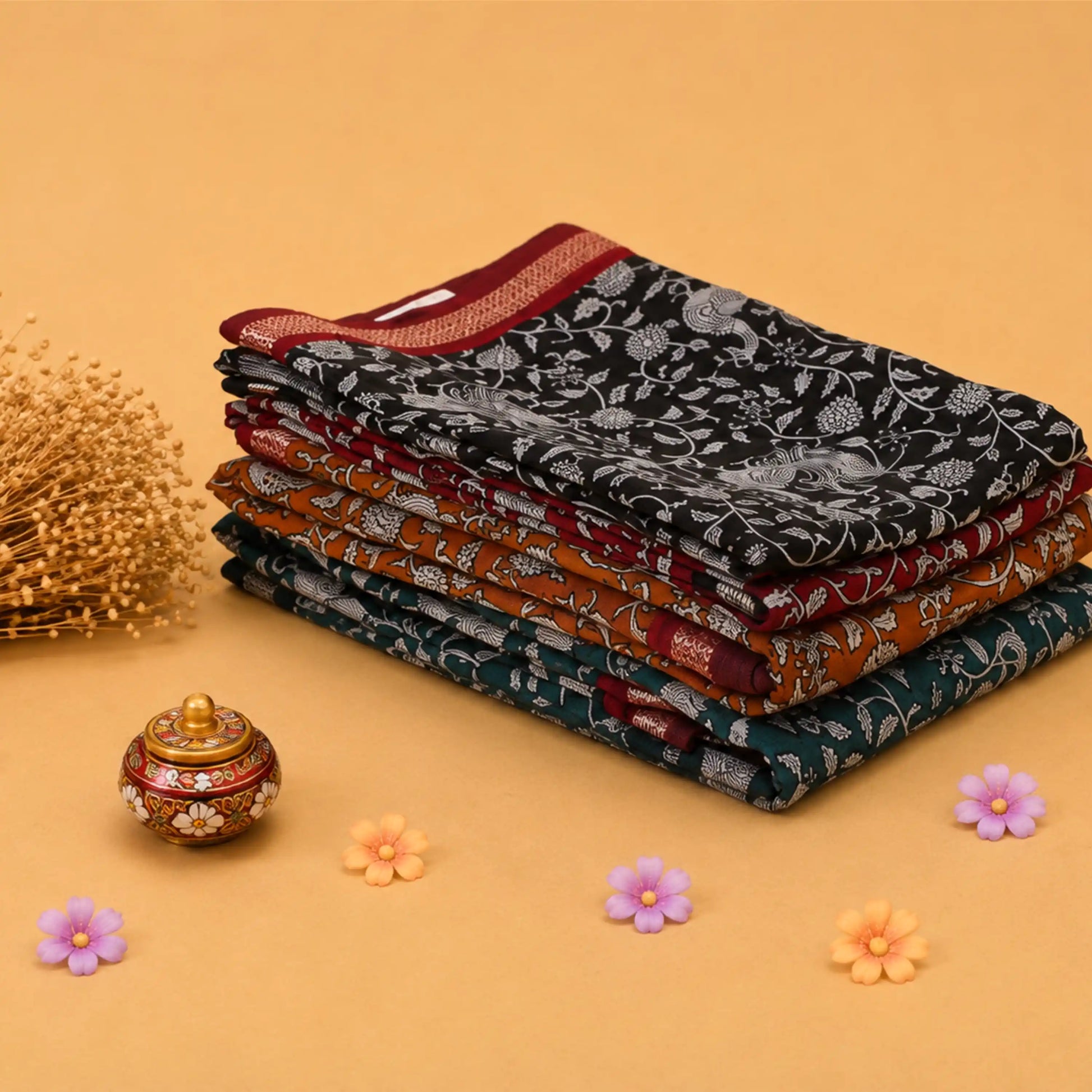 Semi Chanderi saree with intricate white floral print on black fabric maroon border folded stack front angled view.