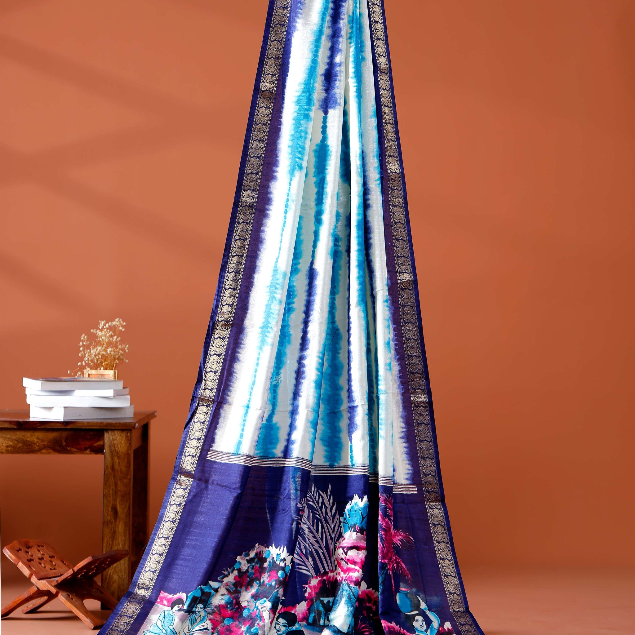 Elegant Navy Blue shades and the rural scenic artwork Dola Saree
