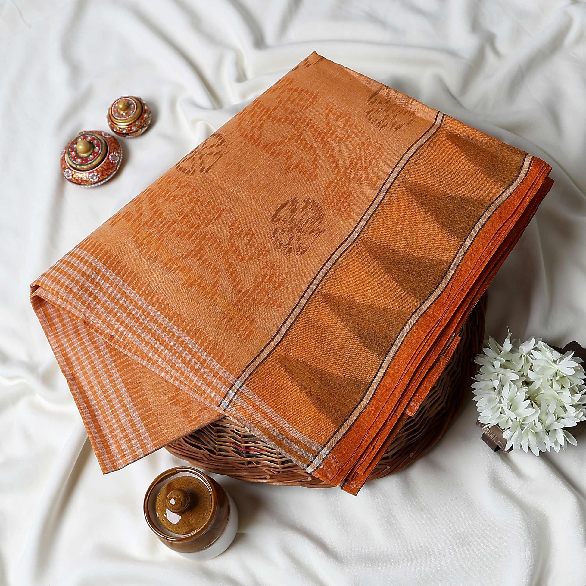 Orange Bengal Cotton Saree Featuring Subtle Woven Motifs And Temple Border Folded Close Up View
