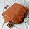Dark Orange Bengal Cotton Saree Featuring Subtle Woven Motifs And Temple Border Folded Close Up View
