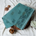 Bengal Cotton Saree With Subtle Floral And Abstract Woven Motifs In Teal Folded Close Up Display View
