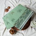 Bengal Cotton Saree With Subtle Floral And Abstract Woven Motifs In Green Folded Close Up Display View