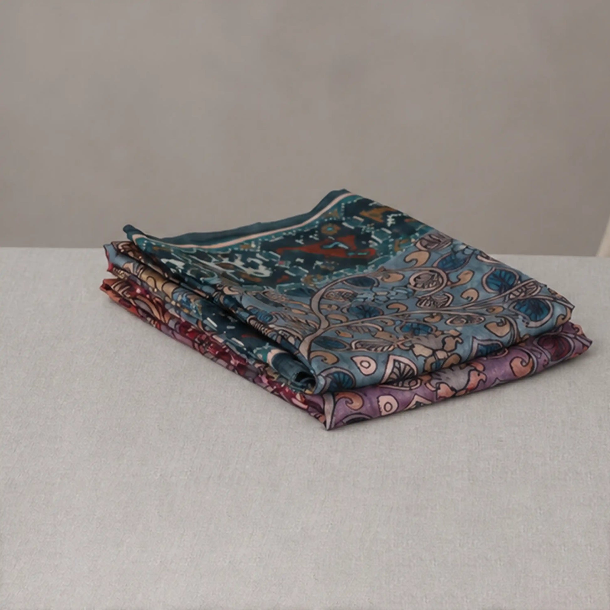 Tussar saree with multicolor artistic print, green woven border, neatly folded stack front view