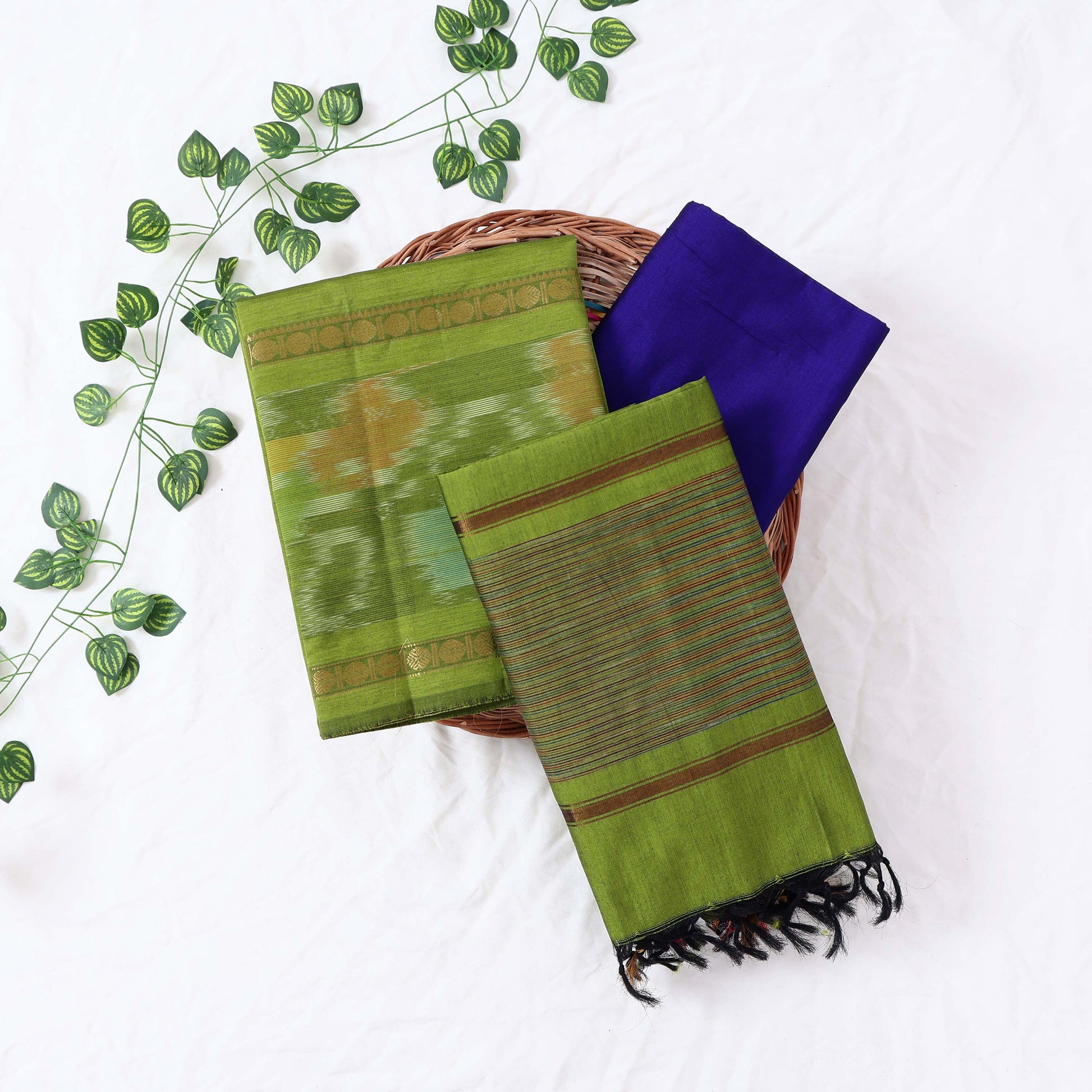 Top View Of Light Green And Blue Salwar Suit Material With Striped Dupatta, Ikkat Woven Border, Tassel Details & Fabric Piece
