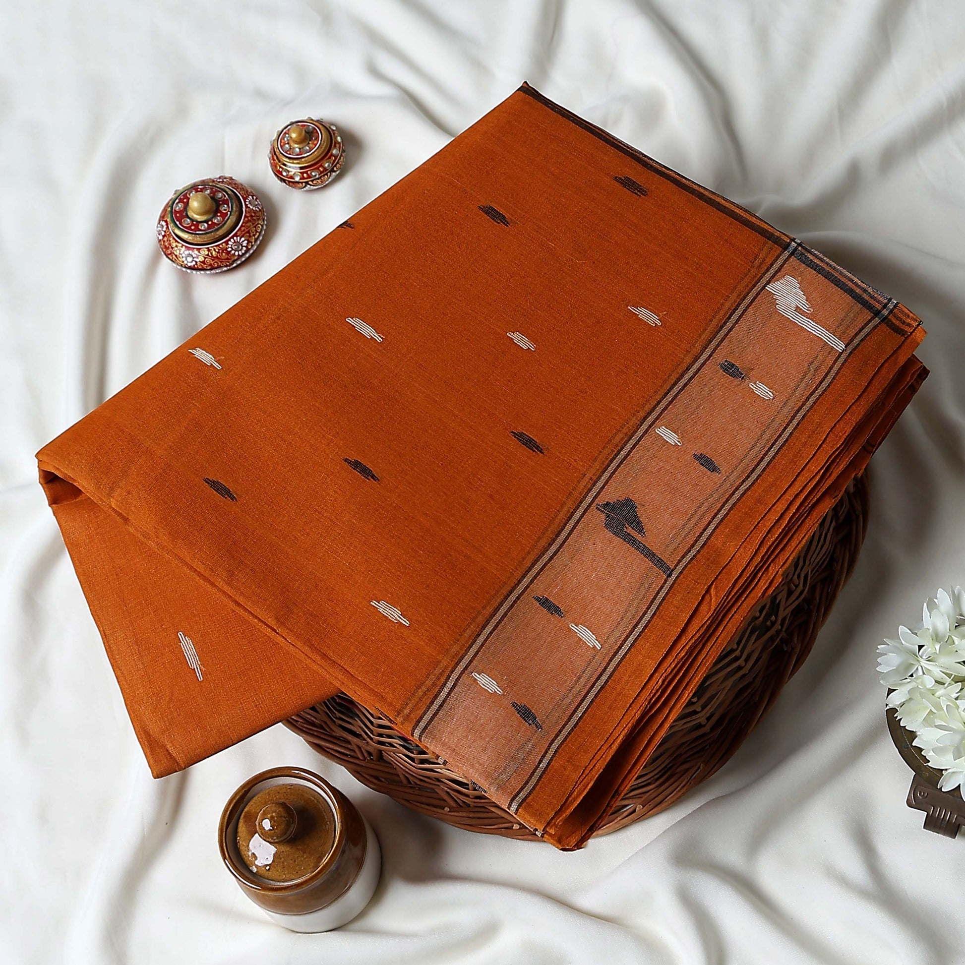 Bengal Cotton Saree With Subtle Woven Motifs And Decorative Border In Orange Folded Display Close Up View