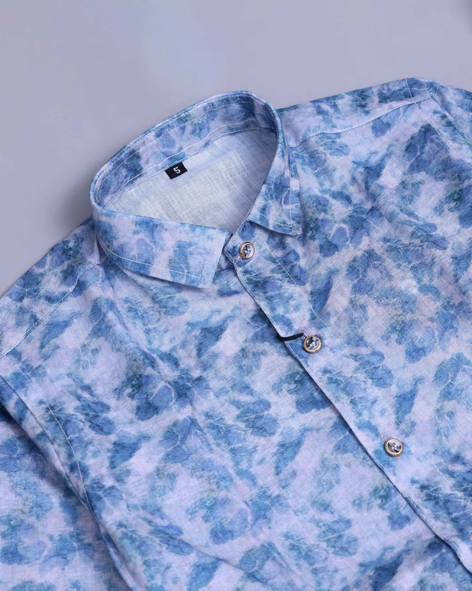 Blue and white patterned shirt on a light gray background