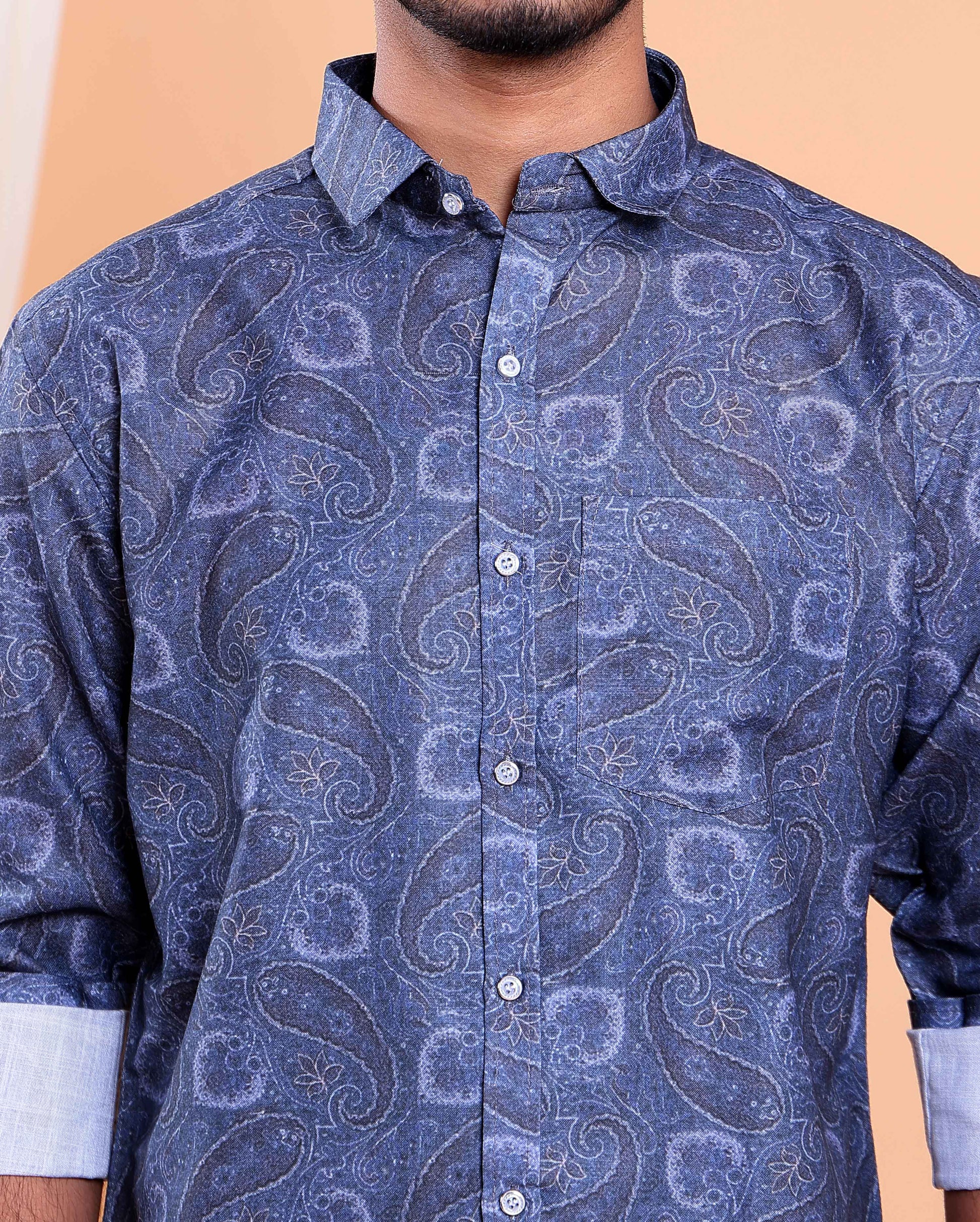 Blue patterned shirt worn by a person on a beige background