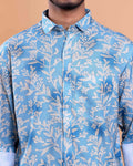 Blue shirt with white leaf pattern worn by a person against a beige background