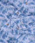 Close-up of a blue tie-dye shirt with buttons and a pocket.